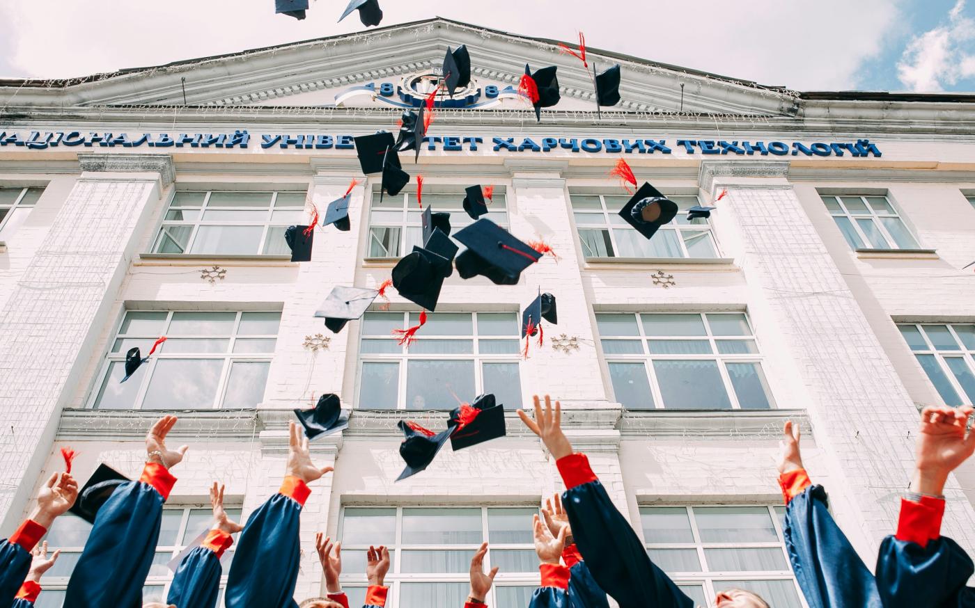 group of fresh graduates students throwing their academic hat in the air by Vasily Koloda courtesy of Unsplash.